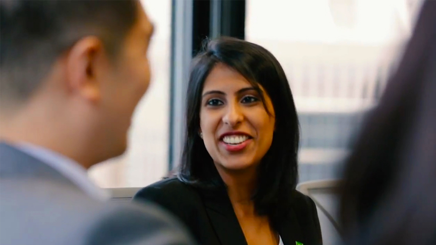 Close-up of a woman's face as she is speaking with a colleague. 