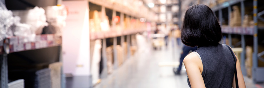 A person in a Costco store with a shopping cart looking down an aisle