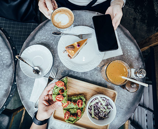 A top-down view of a restaurant table where people are eating trendy foods.